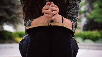 A woman folding her hands in prayer